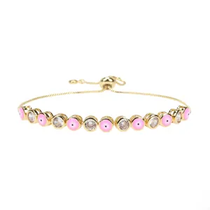 Detail of adjustable gold-plated bracelet with pink evil eye beads and clear zircons