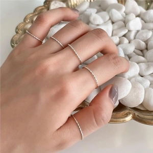 Minimalist S925 sterling silver twist rings stacked on hand with a modern texture