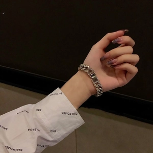 Bracelet gourmette argenté avec strass brillants porté par un mannequin sur fond noir