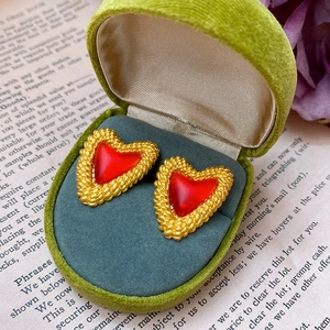 Close-up of vintage heart ruby earrings in a premium green velvet gift box