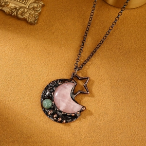 Detail of vintage copper moon pendant with rose quartz and green aventurine stone