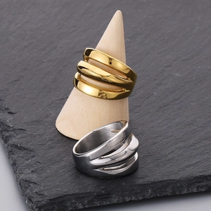 Detailed view of gold and silver triple-layered stainless steel rings on a display stand