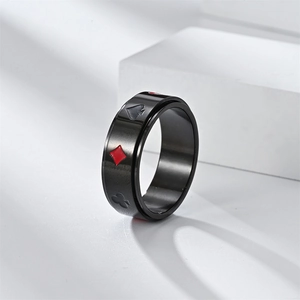 Macro detail of rotating black poker card ring featuring spades and hearts patterns