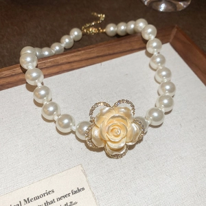 Detail of multi-layer pearl necklace with champagne rose pendant and crystal inlay