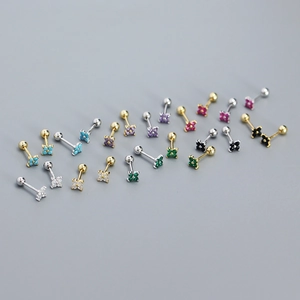 Macro view of multi-colored zircon four-leaf clover stud earrings in silver and gold