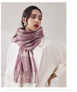 Détail d'une écharpe d'hiver à carreaux lilas et crème avec franges sur un manteau blanc