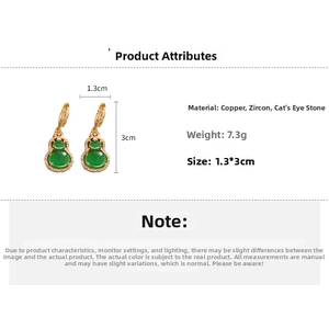 Detail view of gold-plated gourd earrings with green cat-eye stone and cubic zirconia