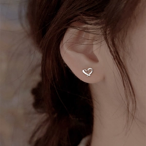 Minimalist s999 sterling silver hollow heart stud earrings on model for women