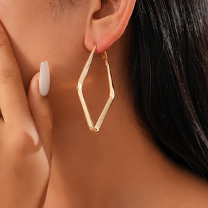 Minimalist geometric rhombic gold hoop earrings for women shown on a model