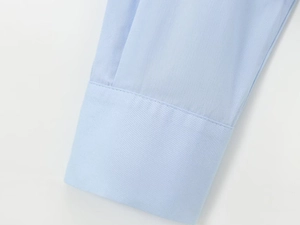 Detailed close-up of light blue cotton poplin sleeve showing fine stitching and fabric texture