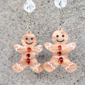 Détail macro de boucles d'oreilles bonhomme de pain d'épices avec strass rouges brillants