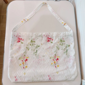 Detail of floral cotton tote bag featuring red and pink flowers with Swiss dot texture