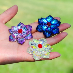 Detailed close-up of multi-faceted floral crystal pendants in purple, blue and white colors