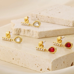 Détail de boucles d'oreilles vintage avec monture dorée, perles et zircons en zircon