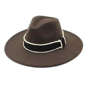Detailed view of brown wool fedora hat with black grosgrain ribbon and white bead trim