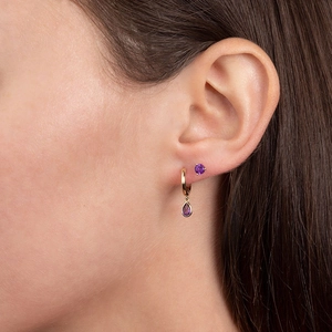 Close-up of S925 needle gold earrings featuring purple zircon teardrop pendants on model