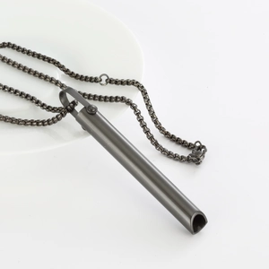 Detailed view of dark grey titanium steel mindfulness necklace on white display plate