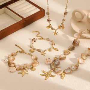 Golden stainless steel ocean jewelry set with shell pendants and starfish charms