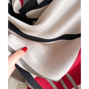 Detail of red and black herringbone woven scarf texture with soft draped fabric handle