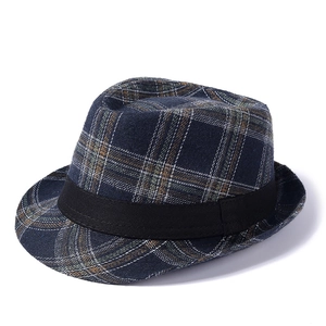 Macro shot showing texture of navy plaid wool fabric and black ribbon on the fedora hat