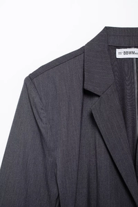 Close-up of charcoal grey pinstripe blazer lapel with high-quality fabric texture