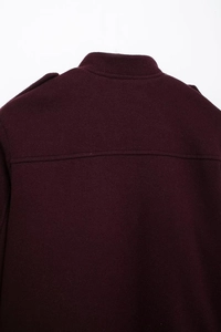 Dettaglio posteriore del cappotto in lana bordeaux scuro con spalline e tessuto denso
