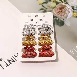 Close-up of six mini resin hair claws with black speckles on a cute cat display card