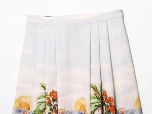 Detail of tropical print midi skirt showing pleat textures and concealed side zipper