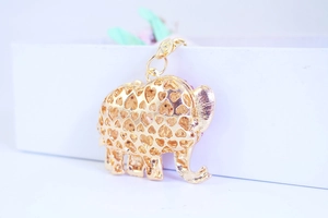 Macro shot of gold elephant keychain featuring intricate hollowed-out heart pattern