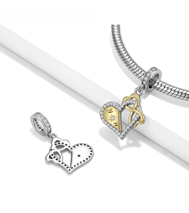 Macro shot of 925 silver heart charm with gold accent and zircons on snake chain