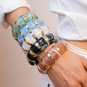Close-up of colorful resin bracelets with marble texture and gold metal accents