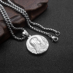 Macro shot of silver Greek medallion pendant with religious embossing on heavy box chain