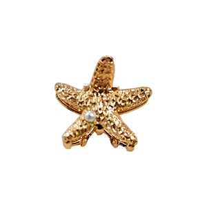 Golden starfish hair claw with hammered texture and a central pearl on white background