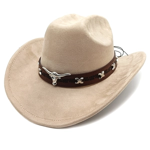Close-up of beige suede cowboy hat with brown band and silver bull head metal ornament