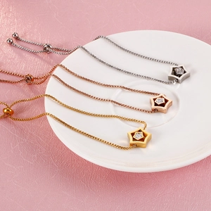 Star charm bracelets in gold, silver and rose gold with zircon on a white plate