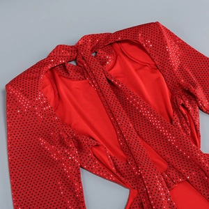 Détail de la robe à paillettes rouges montrant le col rond et la texture de l'épaule