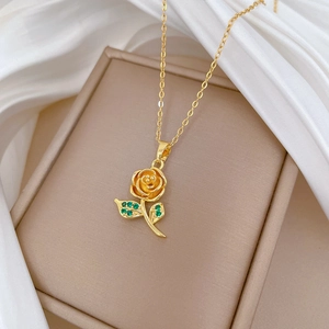 Elegant gold rose pendant necklace with green leaf stones on soft white silk backdrop