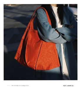Detail of red oversized nylon tote bag with unique crinkle texture and model street style