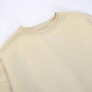 Gros plan du col rond beige en maille côtelée montrant la qualité supérieure du tissu