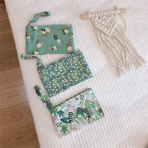 Detailed view of three floral cotton mini pouches with zipper closure and wrist straps