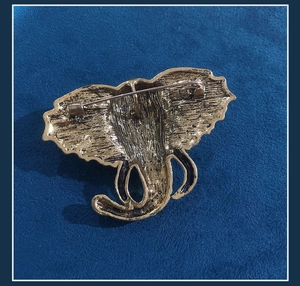 Detailed view of the golden elephant brooch reverse side showing the pin fastener mechanism
