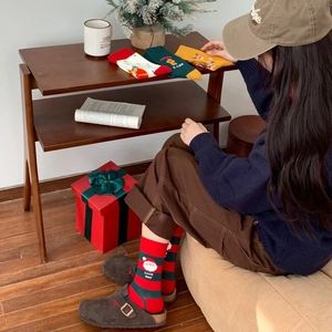 Detailed close-up of Christmas themed crew socks with gingerbread and Santa patterns