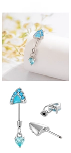 Detail of heart-shaped blue crystal navel piercing with threaded screw bar design