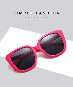 Close-up of oversized square hot pink sunglasses with dark lenses on a minimal background