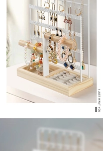 Detailed view of jewelry stand showing necklace hooks and earring plate with wooden base