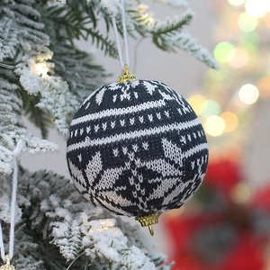 Detailed view of dark blue and white knitted Christmas ball with snowflake pattern