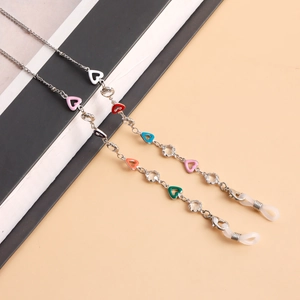 Detail of colorful heart enamel charms and transparent beads on a silver eyewear chain