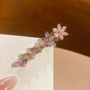 Détail d'une pince à cheveux fleurs en cristal rose et violet avec base dorée
