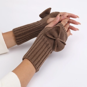 Detail of dark brown knit fingerless gloves featuring a large decorative bow on the back