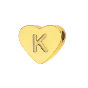 Macro shot of gold-plated heart bead featuring an embossed letter K with polished finish